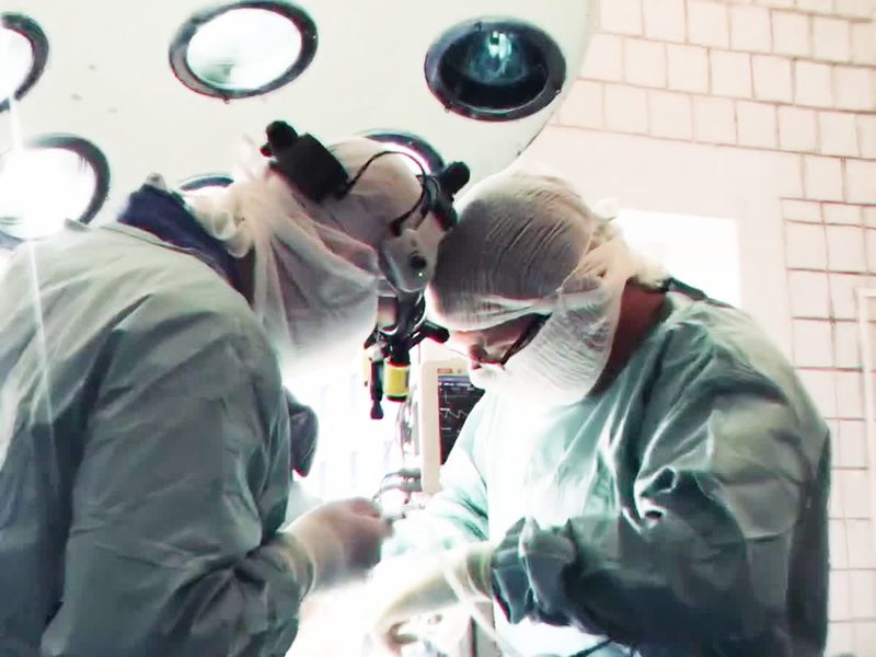 Surgeons working under an operating microscope